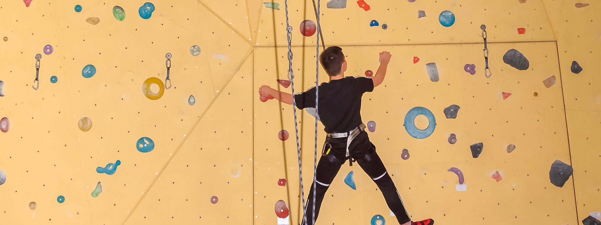 Quelle: Blumenstadt Tessin Ein Jugendlicher hängt gesichert an einer Kletterwand.