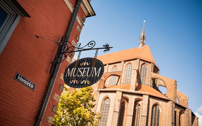 Das Museumsschild vor der Kirche St. Nikolai in Wismar