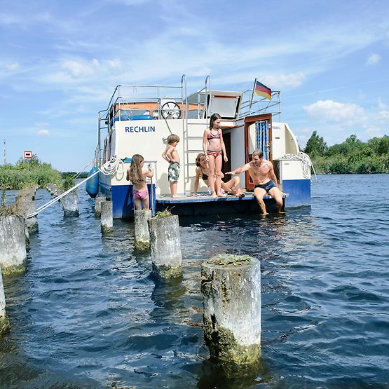 Ein Hausboot mit Familie auf der Peene