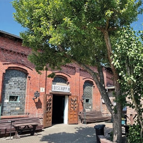 Blick auf Backsteinhalle mit Eingangsbereich zum Lokschuppen Pasewalk
