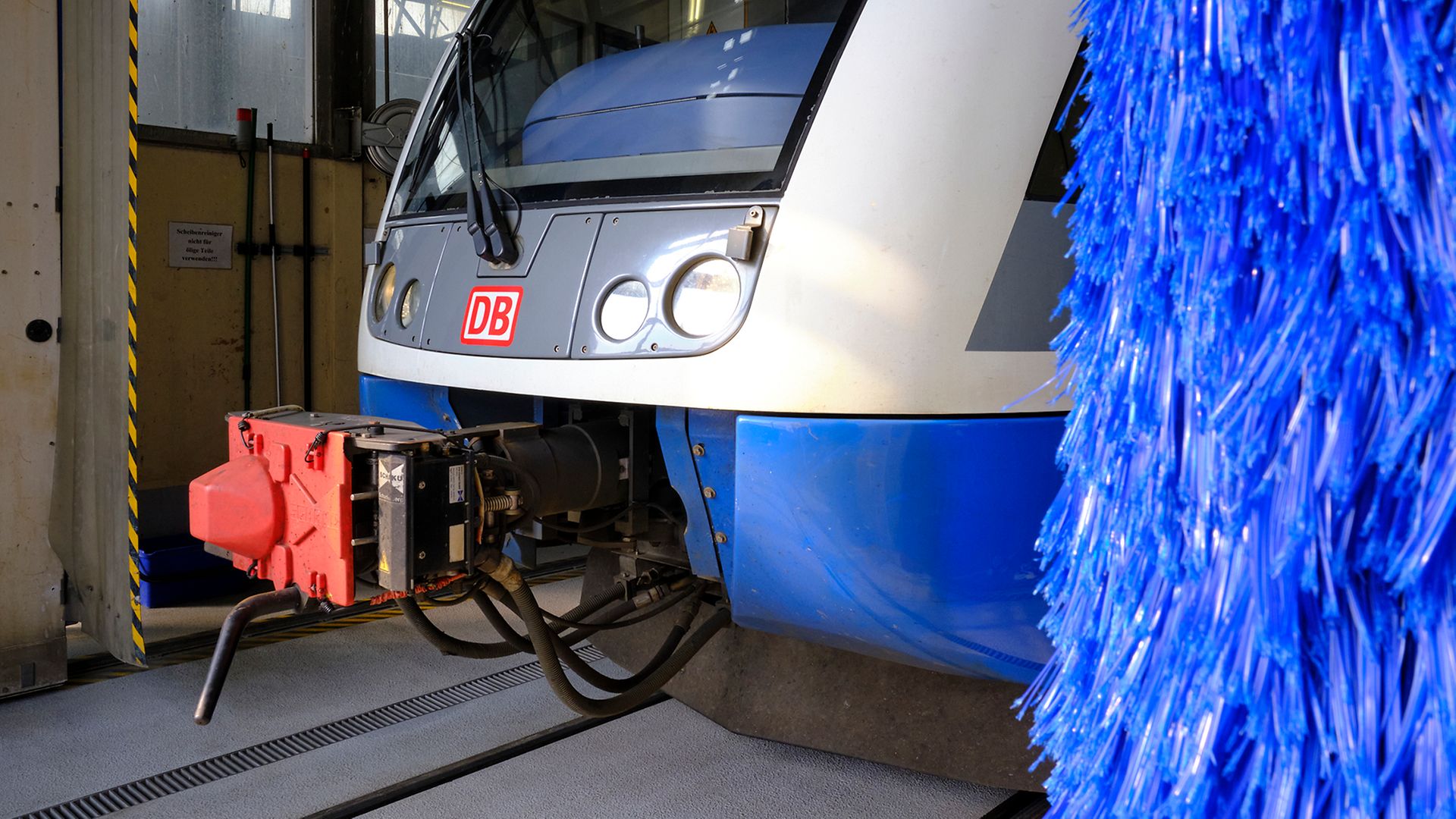 Ein weiß-blauer UBB-Zug steht in der Werkstatt der Usedomer Bäderbahn neben der Waschanlage.
