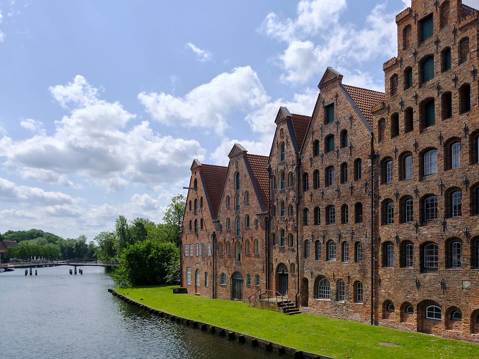 Seitlicher Blick auf die Lübecker Speicherhäuser der Backsteinrenaissance, im Vordergrund die Trave