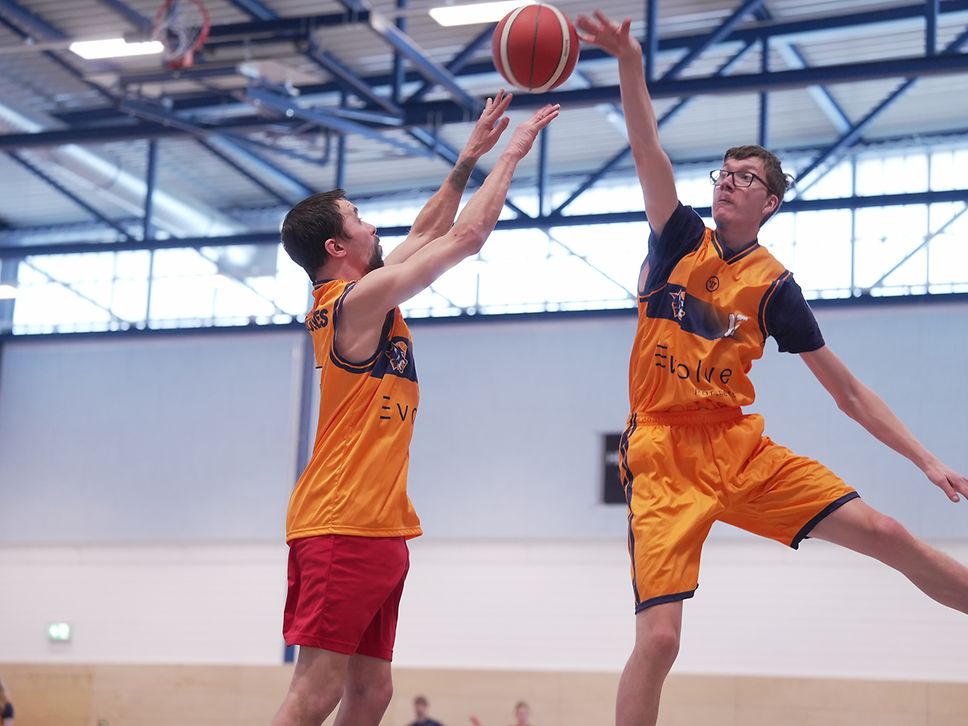 Zwei Basketballer springen nach dem Ball