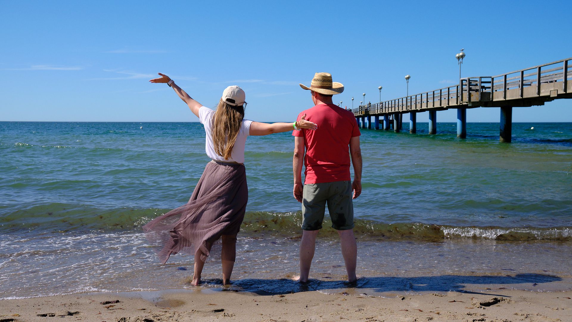 Maike Bäßler und Ingo Ruff in Rückenansicht vor der Ostseebrandung in Graal-Müritz