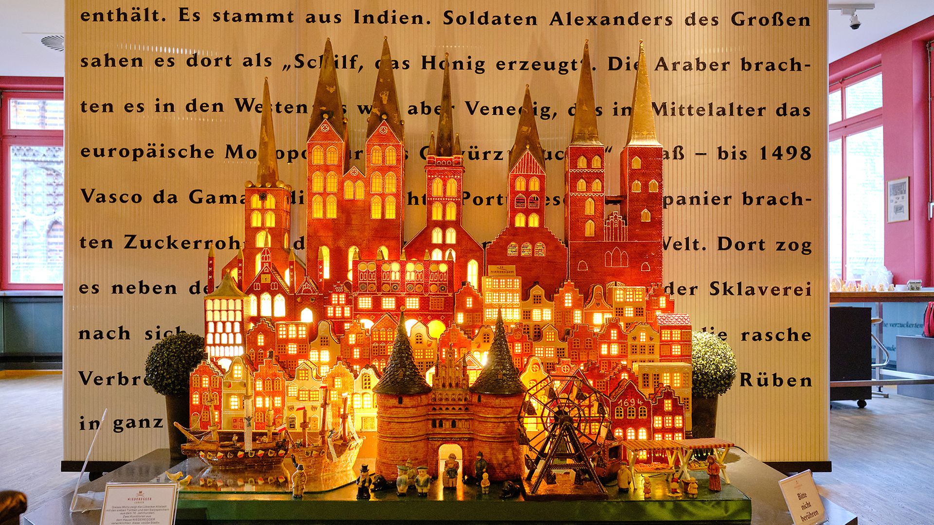 Das Holstentor mit Lübecks Stadtkulisse aus Marzipan gefertigt und beleuchtet im Marzipanmuseum von Niederegger Marzipan