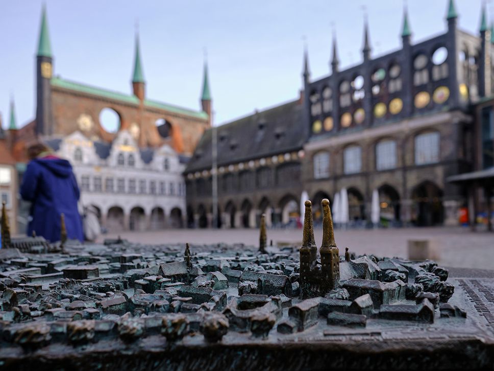 Blick auf bronzenes Stadtmodell auf dem Lübecker Markt, im Hintergrund leicht verschwommen das Rathaus.