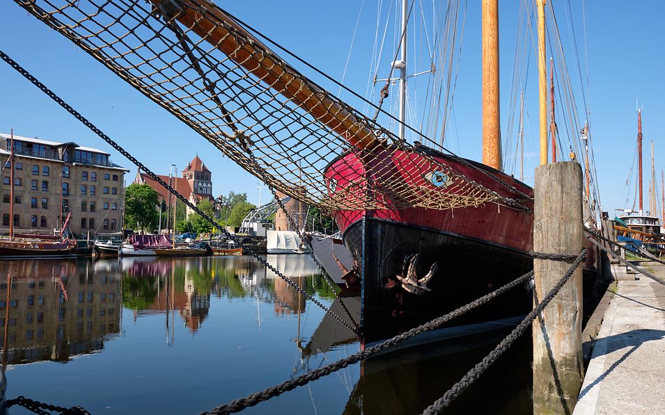 Ein rot-schwarzes Segelschiff im Museumshafen Greifswald