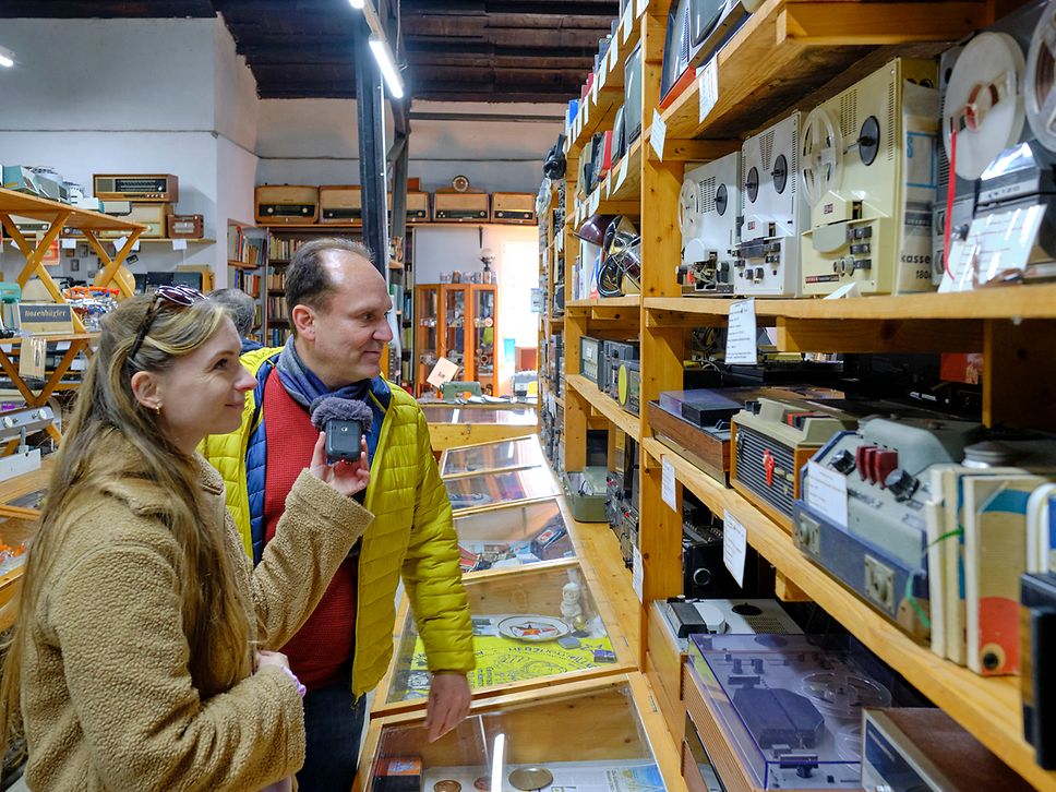 Maike und Ingo betrachten im DDR-Museum alte Tonbandgeräte.