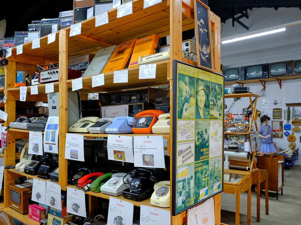 Ein Regal voller altmodischer Telefone mit Wählscheibe oder Tasten im DDR-Museum auf Usedom