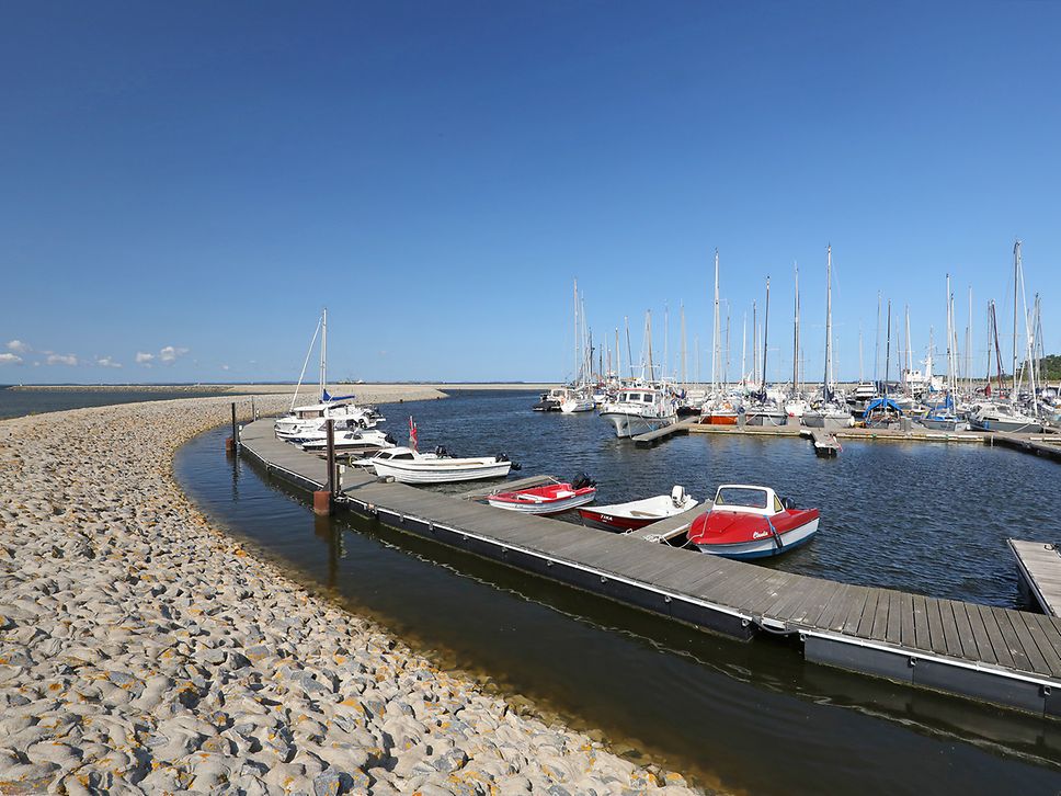 Boote auf dem Wasser der Marina Lubmin entlang eines Stegs direkt am Strands