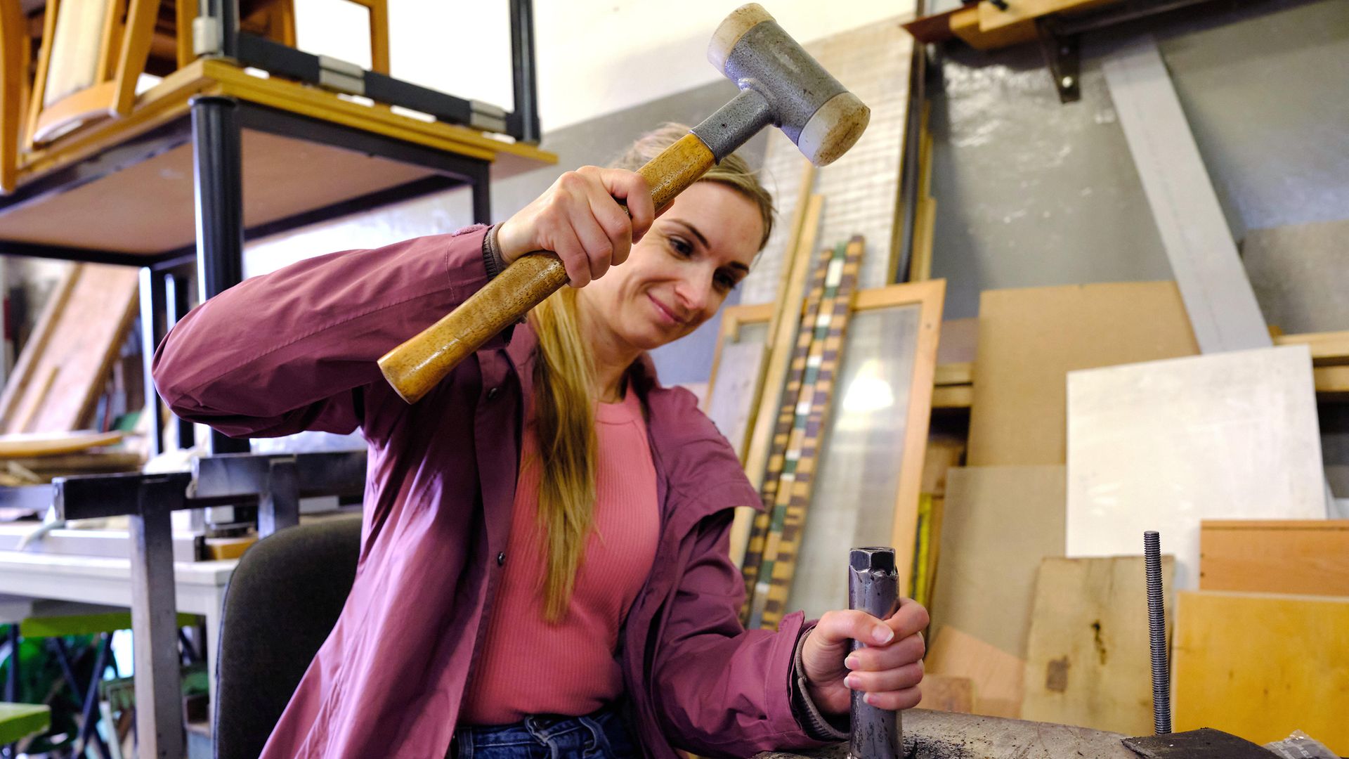 Podcasterin Maike mit dem Hammer in der Hand in der Werkstatt der Miniaturstadt Bützow