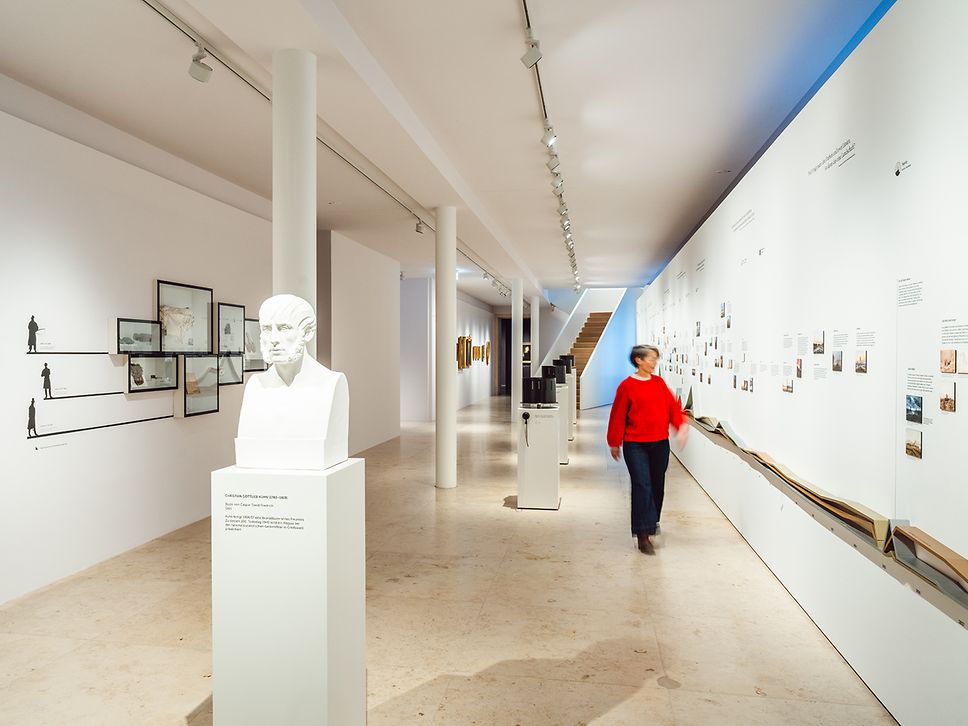 Die Galerie der Romantik im Pommerschen Landesmuseum mit kleinen Bildern an weißen Wänden, einer Skulptur im Vordergrund 